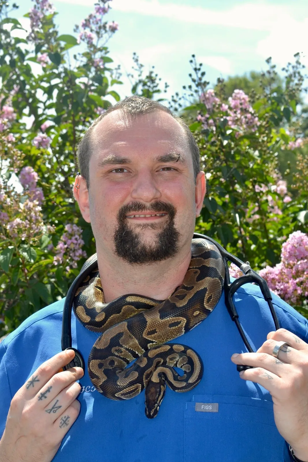 Christopher Costa with a snake outdoors